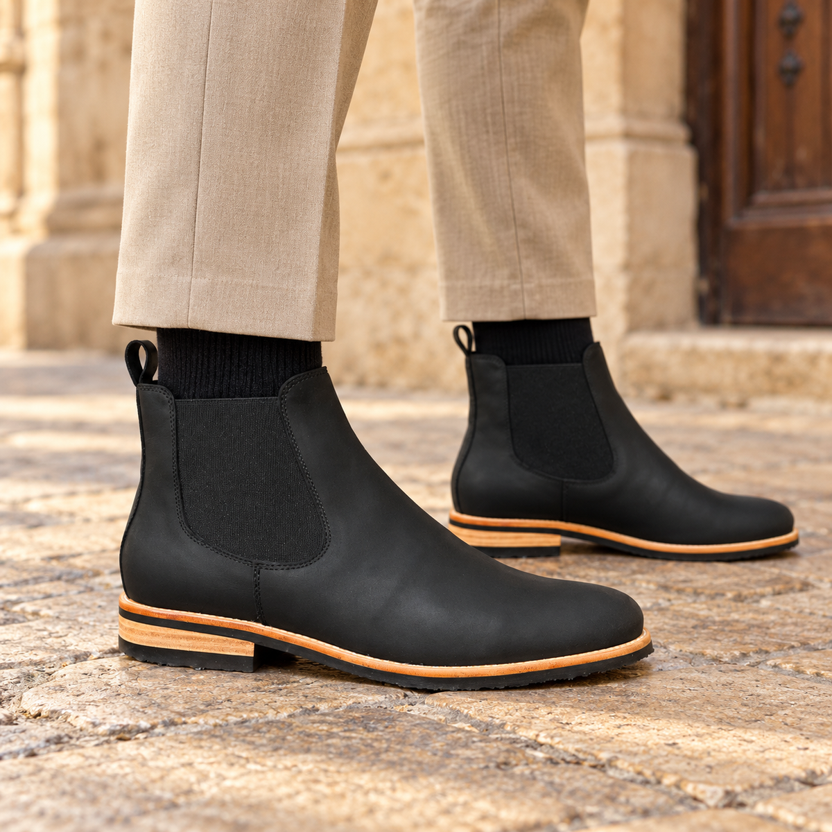 Botines negros Rodrigo Valentino con pantalón beige en calle de piedra