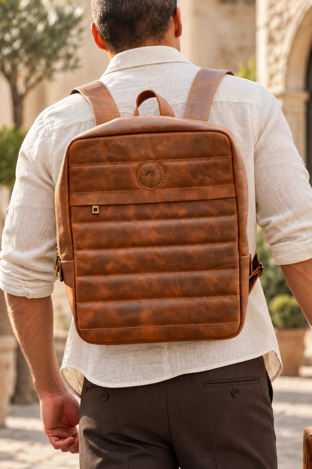 Mochila Bonnie Tostado con modelo, vestuario neutro y fondo de piedra
