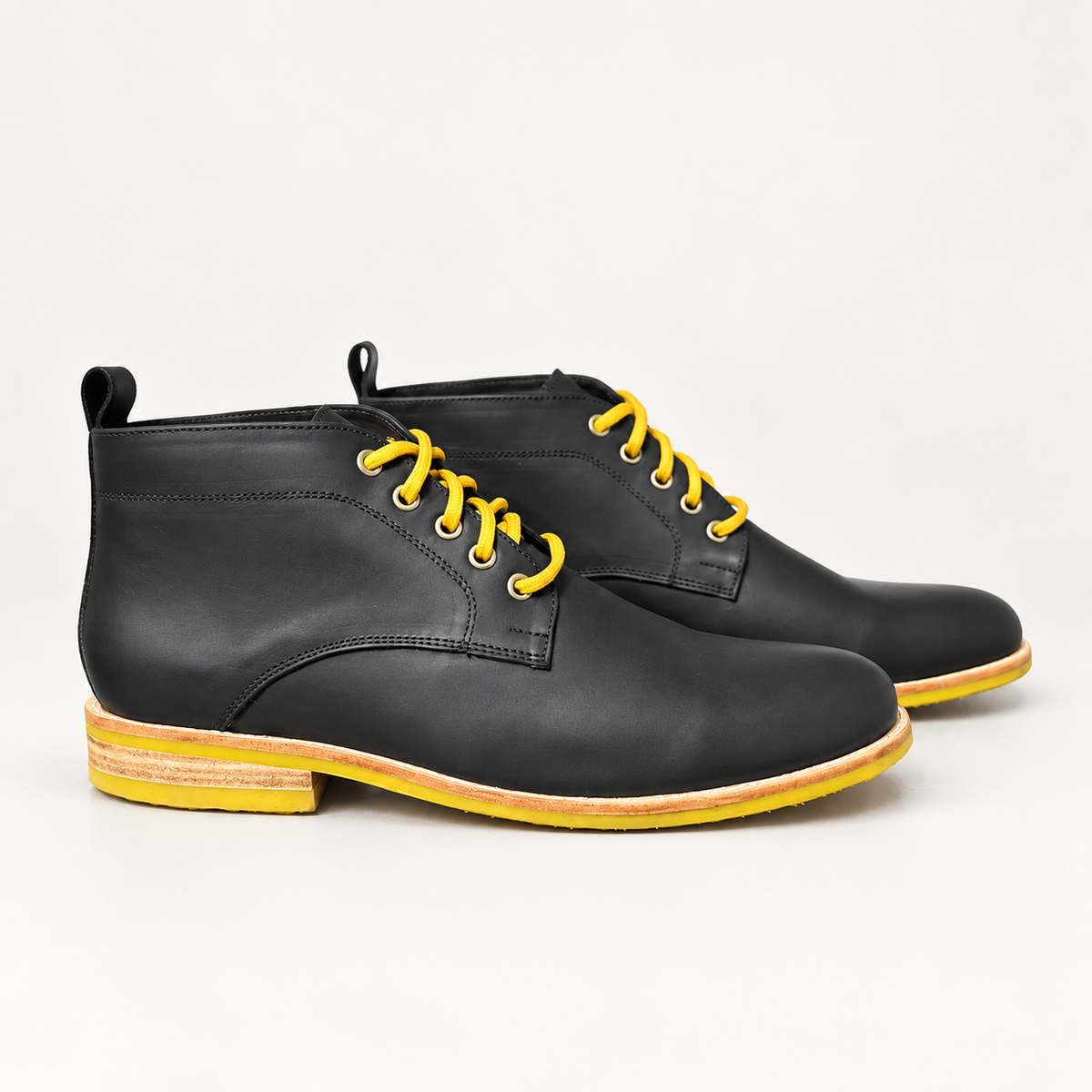 Par de botines Arthur Negro Graso x Amarillo sobre fondo blanco gris