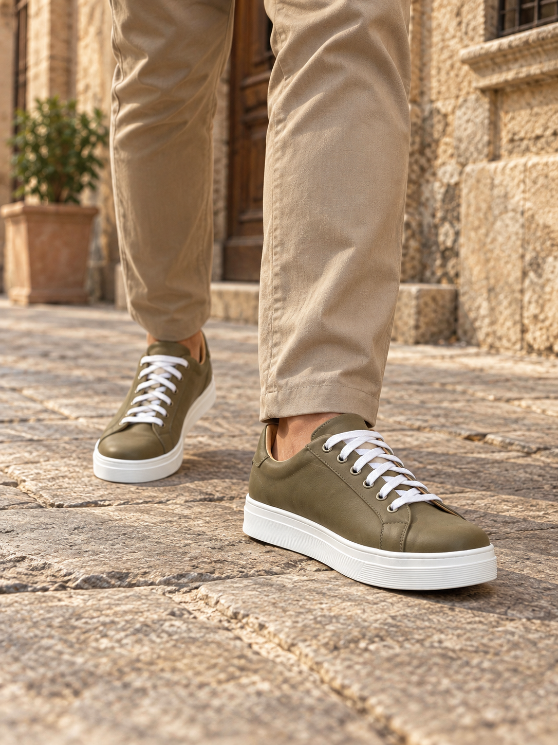 Modelo hombre usando zapatillas Isahia Verde Oliva en calle antigua