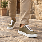 Modelo hombre usando zapatillas Isahia Verde Oliva en calle antigua