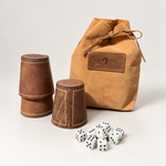 Juego de cachos de cuero y dados con bolsillo camel sobre fondo blanco gris